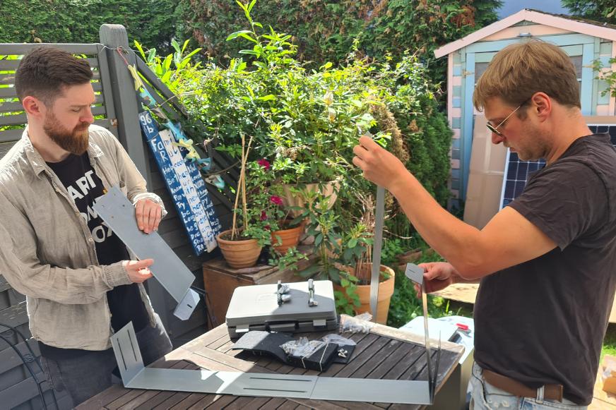 Die Halterung eines Solarmodules wird zusammengebaut und ist sehr kompliziert, die Experten versuchen das richtige Zusammenbauen herauszufinden.